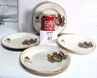 Front view of four plates displaying EIIR coronation crest and gilt rims with reference object