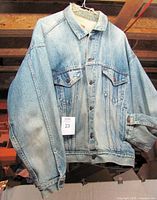 Front view of Levi's denim jacket showing light stonewash color, chest pockets, button front, size XL tag visible