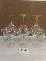 Seven of the ten coupe glasses displayed; three inverted showing wide bowl style, four upright showing smaller bowl style