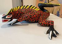 profile view of painted wood lizard