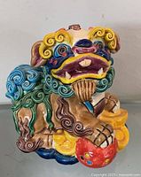 Front view of multicolored Koji Pottery Cochin ceramic foo dog figurine