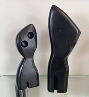 Front view of both black abstract sculptures showing design and height comparison