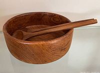 Top view of wood salad bowl with two servers resting inside