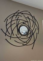 Full view of abstract metal swirl mirror on wall