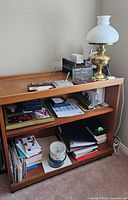 Front view of light wood table with two shelves and contents on shelves
