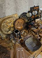 Overall view showing assortment of brass, wood and metal décor pieces