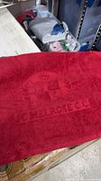 Close-up of towel showing red color and woven Melrose Country Club crest