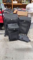 Full view of five black rolling luggage pieces