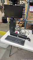 Overall view of Dell tower, monitor, peripherals on table
