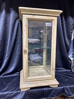 Front view of distressed wood display cabinet with glass door