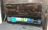Front view of Samsung curved TV powered on showing smart hub interface
