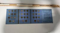 Full view of three-panel Whitman album with coins and information panel