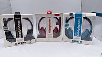 Front view of three boxed Targus Studio headphones in black, red, blue