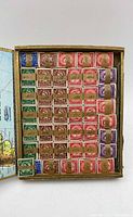 Open cigar box showing rows of Queen Elizabeth II stamps
