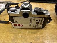 Rear and top view of Nikon FM camera body with strap and lot label visible