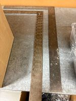 Two steel carpenter’s squares laid flat showing etched graduations