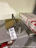 Overall view showing tile cutter on shelf with lot tag