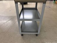 Side view of cart showing two shelves and fixed rear casters