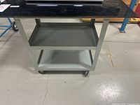 Front view showing three shelves, arborite top, caster wheels