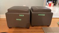 Two gray leather ottomans side by side