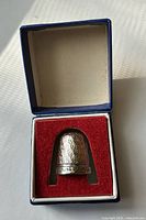 Open presentation box showing thimble inside