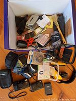 Overview of entire lot inside box showing cameras, chargers, accessories