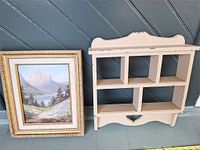 Framed print and chalk-painted wooden shelf side by side