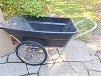 Side view of black poly garden cart with metal frame and wheels