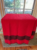 Red wool blanket draped to show overall color and stripe