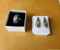 Ring in box and pair of earrings on backing