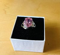 Front view of sterling ring with large pink stone in presentation box