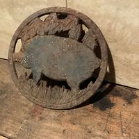 Front view of rusted round pig trivet
