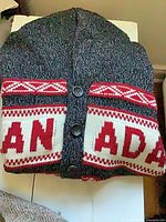 Front of grey cardigan showing CANADA intarsia and buttons