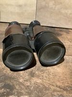 Front view of binoculars showing objective lenses and leather panels