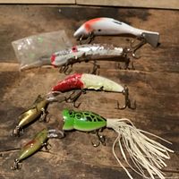 Group shot of six lures and bead bag on wood surface