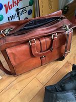 Front view of brown leather Mancini laptop bag showing main handles, front pockets and zipper