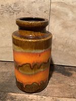 Front view of cylindrical fat lava vase showing glaze colors and shape