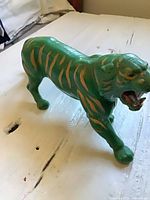 Side view of green tiger figure on tabletop