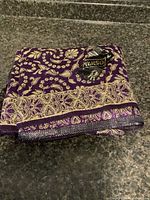 folded purple and gold silk tablecloth on countertop