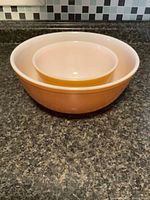 Two nesting Pyrex bowls, smaller inside larger