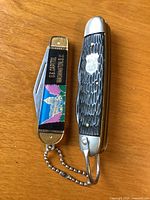 Both pocket knives closed showing handles and size comparison