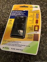 Front view of sealed Leviton Renu USB charger receptacle package showing model and specifications