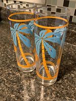 Two palm tree highball glasses standing upright