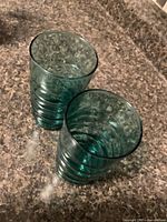 Both green glass tumblers on countertop.