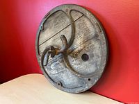 Full view of round keg lid showing cast metal rim, wood insert, locking clamp handle and glass port