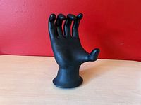 front view of matte black resin hand sculpture