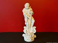 Full view of blanc de chine Li Tieguai figure against red background