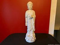 Full view of white porcelain standing Buddha on lotus base