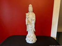 Full view of white porcelain Guanyin statue on lotus base