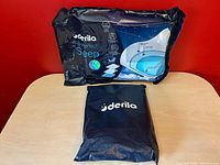 Front view of sealed Derila pillow package beside sealed cover pouch